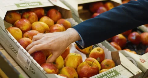 Close up of carton box with red and yellow apples. Caucasian male hand choosing Stock Footage 135345324