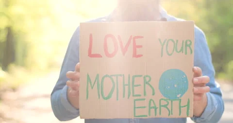 Close up of carton poster in sun rays with words Love your Mother Earth in hands Stock Footage 130487363