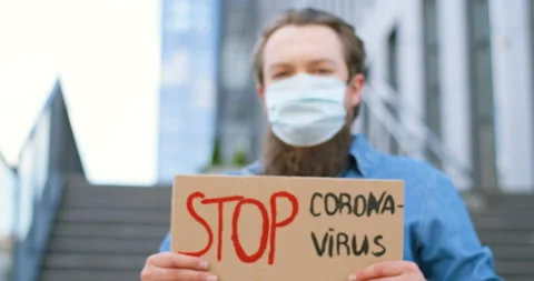 Close up of carton table with words Stop Coronavirus in hands of Caucasian young Stock Footage 130460666
