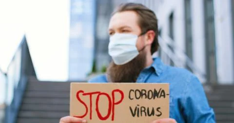 Close up of carton table with words Stop Coronavirus in hands of Caucasian young Stock Photos