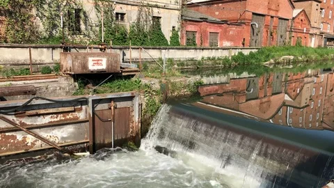 Close up of a cascade in a mirrored canal with a lock near an old factory. Stock-Footage 89811790
