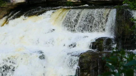 Close Up Of Cascading Water Falls Flowing Over Rock Ledge Into The Shaded Valley Stock Footage 200575024