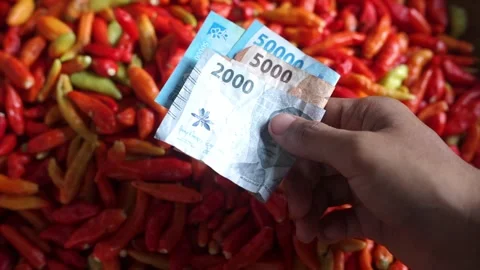 Close-up of a cash transaction using Indonesian rupiah at a traditional market Stock Footage 322633081