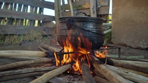A close up of a cast iron pot over a fire Stock Footage 254799770