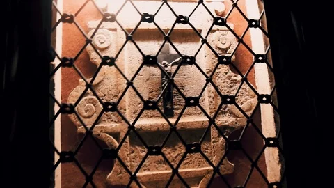 Close-up of the Catholic cross hanging behind bars on the wall Stock Footage