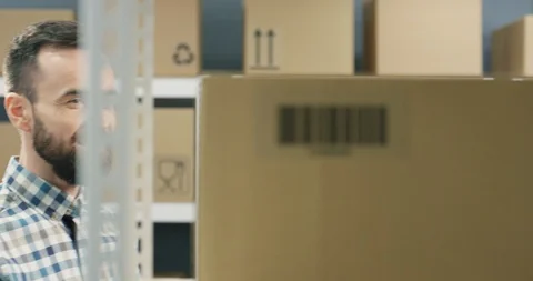 Close up of Caucasian good looking postman taking carton box with bar code from 스톡 동영상 126590958