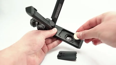 Close up of Caucasian hands inserting batteries into SONY camera gimbal. Stock Footage 135619070