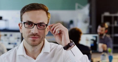 Close up of Caucasian handsome man in white shirt in glasses looking straight in Stock Footage 82445302