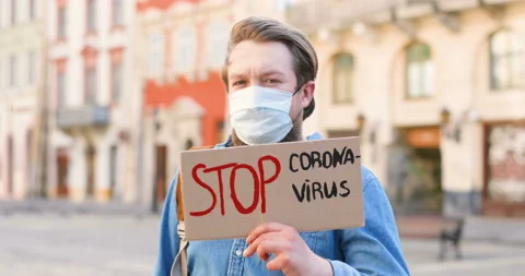 Close up of Caucasian man with beard and in medical mask holding table Stop Stock Footage 130485075