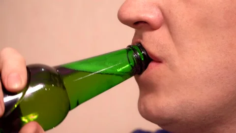 Close up. caucasian man drinks beer from a green bottle Stock Footage 168605360