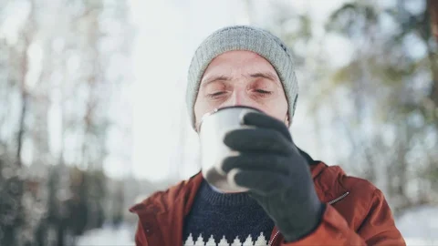 Close-up of a Caucasian man in a gray hat, sweater, brown jacket and gray gloves Stock Footage 128001020