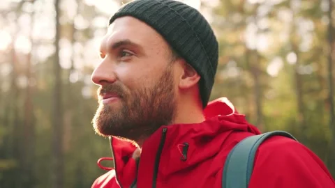 Close up of caucasian man in hat standing in woods in sunlight and taking photos Stock Footage 147068523