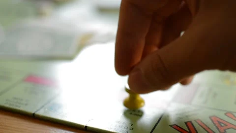 Close-up caucasian man playing with old fashioned monopoly board game. 库存影片 213560865
