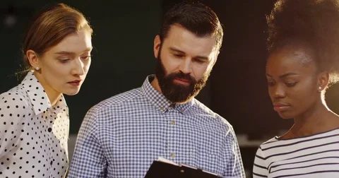 Close up of a caucasian man standing with two co-workers mixed races women and Stock Footage 82446853