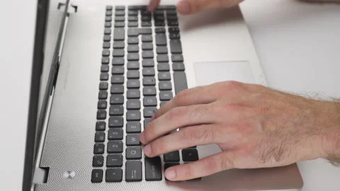 Close up, caucasian man is typing, using keyboard on laptop with his hand Stock Footage 138043233