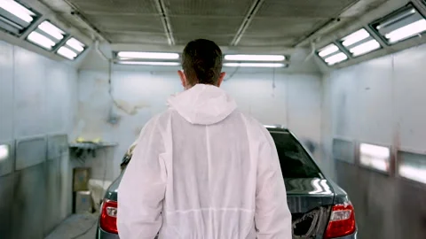 Close up, Caucasian man walking into large painting room fit for one car paked Stock Footage 240321876