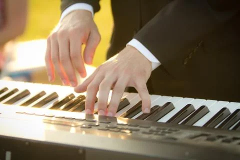 Close up of Caucasian man's hands playing a keyboard. Stock Photos