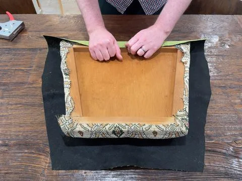 Close up of caucasian man's hands using a staple gun to reupholster a dining roo Stock Photos