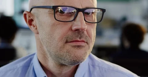 Close up of Caucasian middle aged man in glasses looking on the side and than Stock Footage