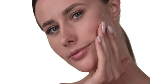 Close up of a Caucasian woman's face, applying moisturizer on her face, rubbing Stock Footage 158021866