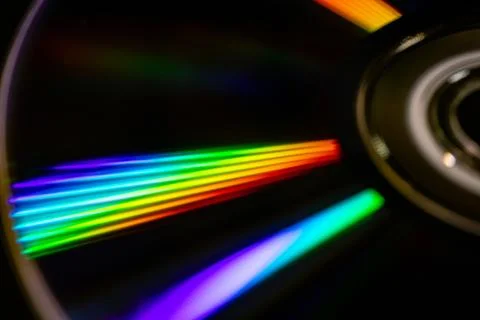 A close-up of a CD in motion with bright rainbow reflections. Stock Photos