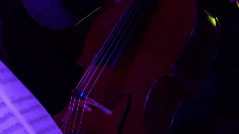 Close up on cello with red/fucsia/violet light. Stock Footage 135325634