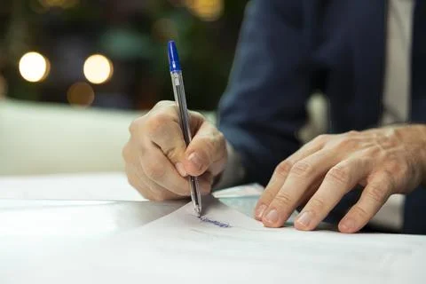 Close up of CEO signing paperwork for final approval at work table Foto stock