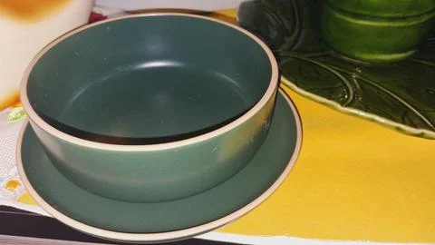 Close-up of a ceramic bowl on a yellow surface. Elegant tableware for dining and Stock Photos