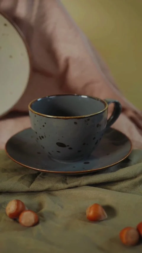 Close-up of a ceramic coffee cup with saucer on a rustic table Video stock 344851488
