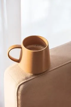 Close Up Ceramic Coffee Mug on Sofa Armrest with Textured Pillows. Cozy Hom.. Stock Photos