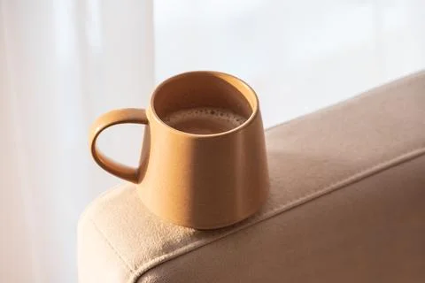Close Up Ceramic Coffee Mug on Sofa Armrest with Textured Pillows. Cozy Hom.. Stock Photos