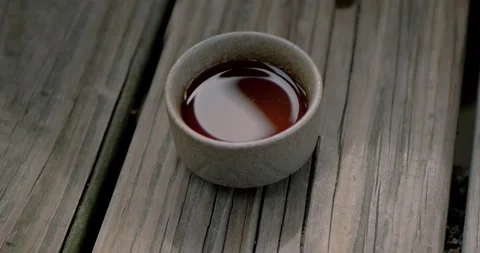 Close-up of a ceramic cup filled with freshly brewed Chinese tea resting... Stock Footage 316914553
