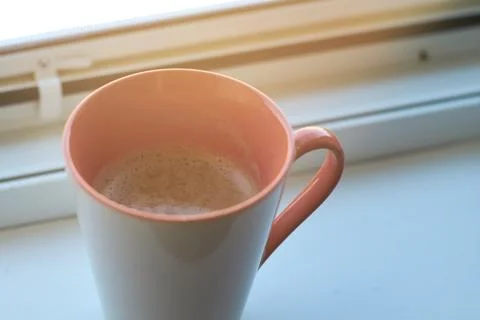 Close-up of a ceramic mug filled with fresh hot coffee placed near a bright.. Stock Photos