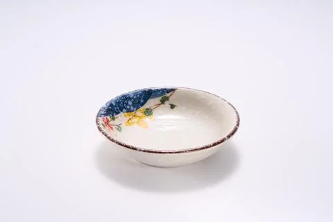 Close-up of ceramic small taste dish with flower spots texture on white bac.. Photos