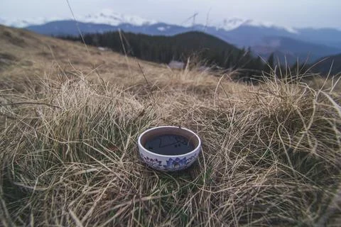 Close up ceramic tea mug standing in dried grass concept photo Stock Photos