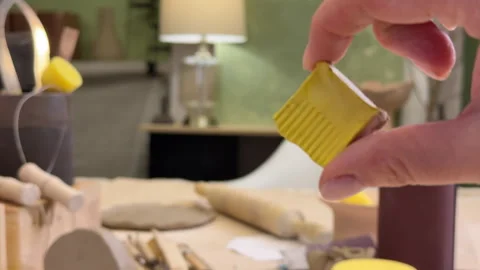 Close-up of a ceramic tile sample in hand against the green wall of a pottery wo Stock Footage 306091612