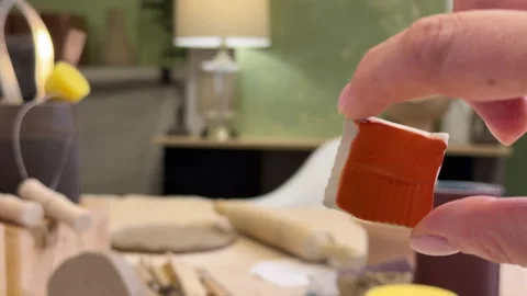 Close-up of a ceramic tile sample in hand against the green wall of a pottery wo Stock Footage 306092663