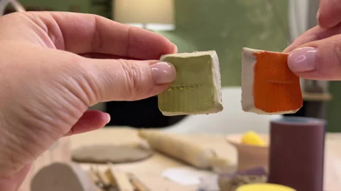 Close-up of a ceramic tile sample in hand against the green wall of a pottery wo Stock Footage 306093660