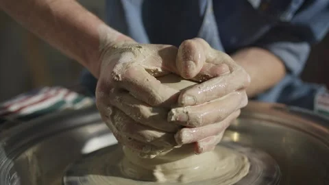 Close-up of ceramist's hands working with clay on the potter's wheel in workshop Stock Footage 244130120