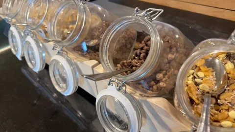 Close-up of cereal jars at breakfast buffet, slow motion movement across row Stock Footage 323531620