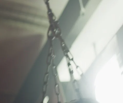 Close up of chain attached to punching bag in day time in gym Stock Footage 147043174