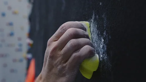 Close-Up of Chalk-Dusted Hand Gripping Yellow Hold on Indoor Climbing Wall Stock Footage 276947852
