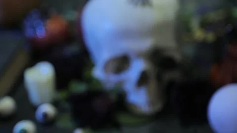 Close-up, change of focus from human skull to black book with pentagram. Vídeos de archivo 141836319