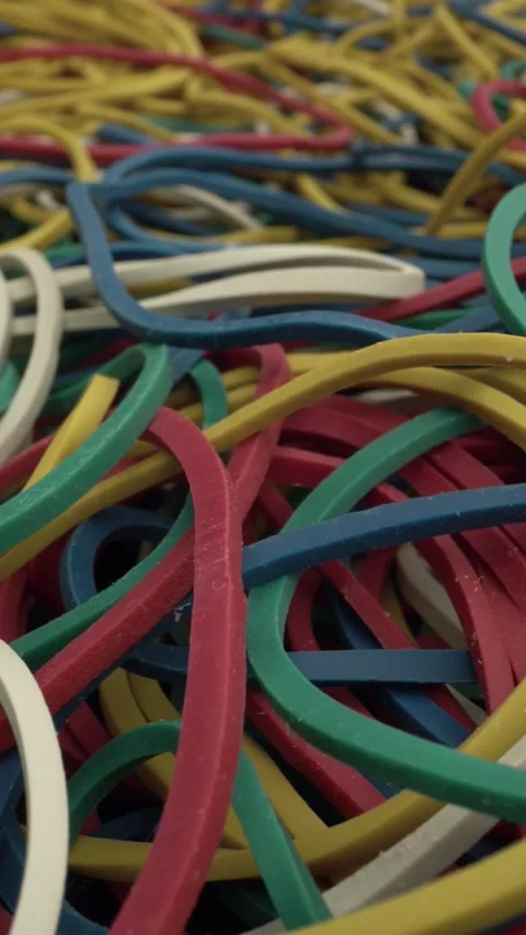 Close-up of a chaotic pile of multicolored rubber bands in red, yellow, blue Stock Footage 341530596
