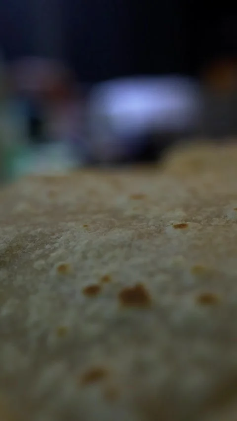 Close-up of chapati dough with blurred cooking setup in background Stock Footage 343876494