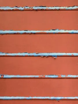 Close up of chapped red paint and metal lines going across abstract backgroun Stock Photos