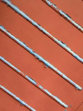 Close up of chapped red paint and metal lines going across abstract backgroun Stock Photos