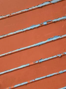 Close up of chapped red paint and metal lines going across abstract backgroun 库存照片