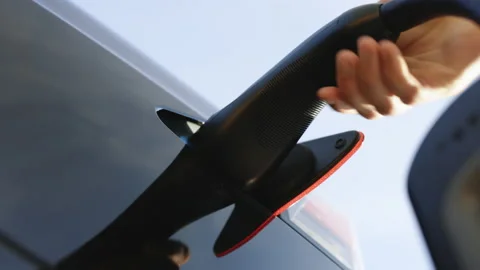 Close up of charging cable connecting to the electric vehicle for charging a Stock Footage 220298620