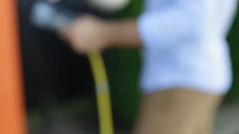 Close up of charging cable in male hands. Power supply connecting to the green Stock Footage 200997043